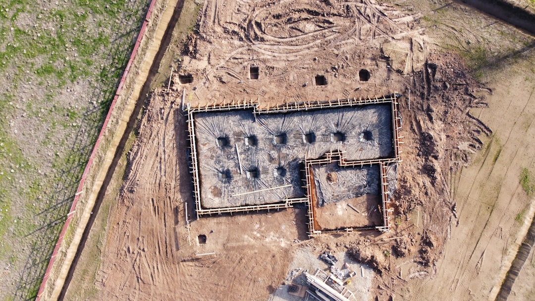 A photo comparing foundation types (slab vs crawl space vs basement) with excavation and concrete work shown on a Kansas jobsite