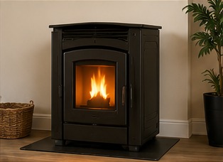 Black pellet stove with glowing flame installed on a floor hearth pad.