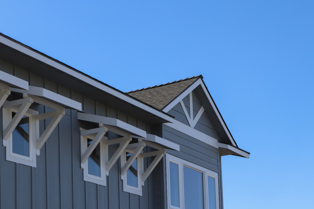 Framing stage of a new house build in Idaho with lumber stacks and roof trusses