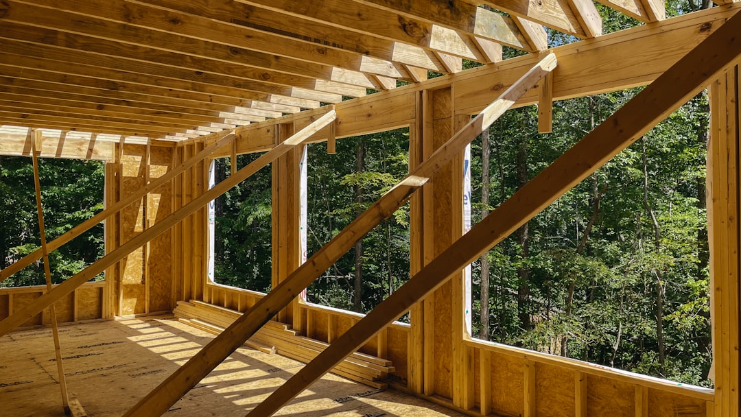 Photo of a New Hampshire home build site showing excavation equipment, framing lumber, and a foundation under construction