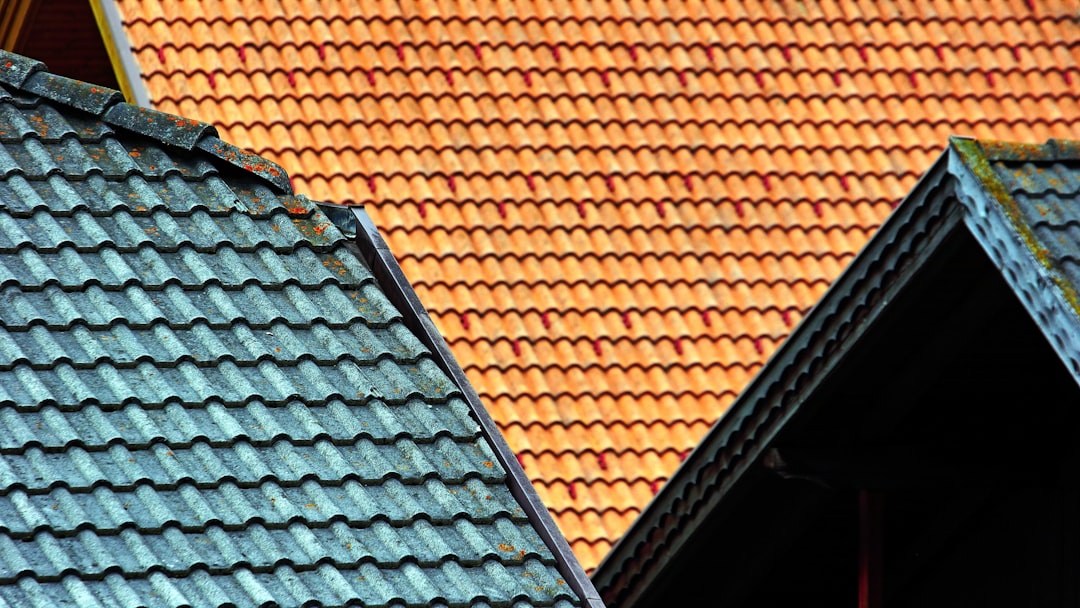Roofing crew installing underlayment and flashing details around valleys and dormers on a complex roof